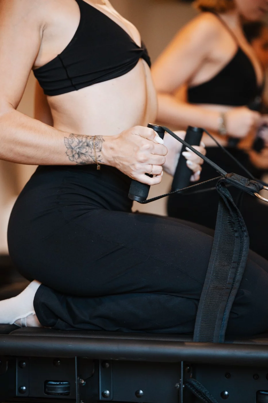 Mains serrées sur les sangles du reformer